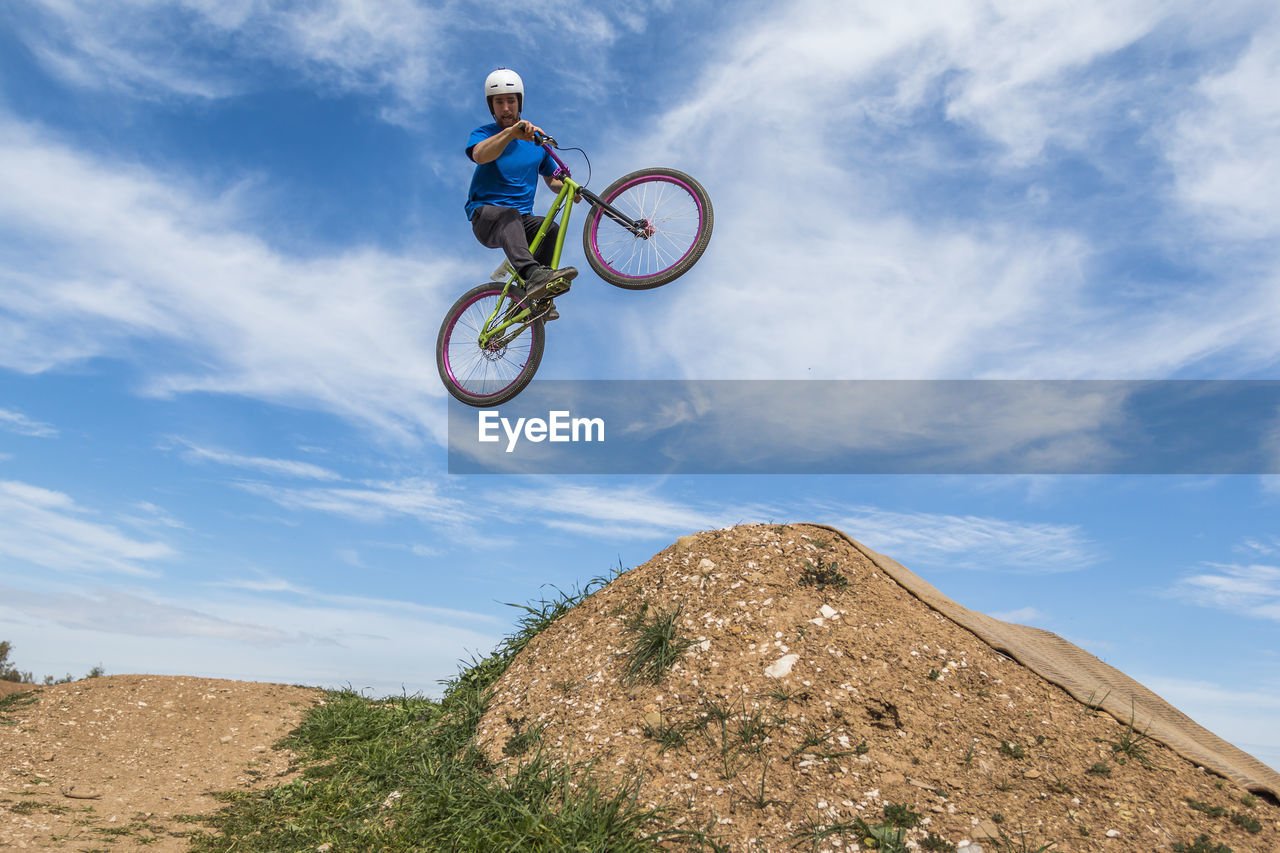 Low angle view of man jumping while doing bmx cycling