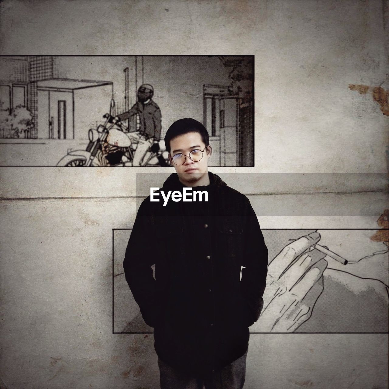 PORTRAIT OF YOUNG MAN STANDING AGAINST WALL