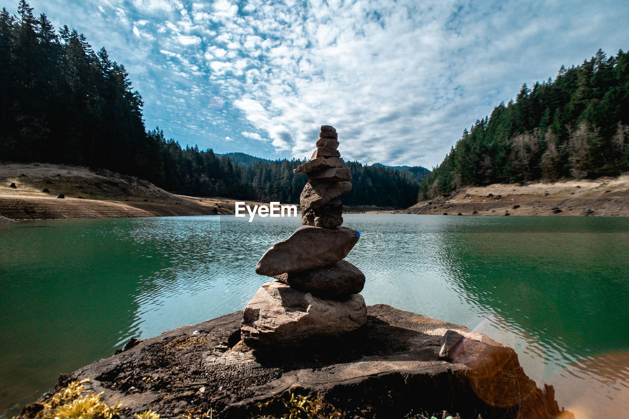 STATUE ON ROCK AGAINST LAKE