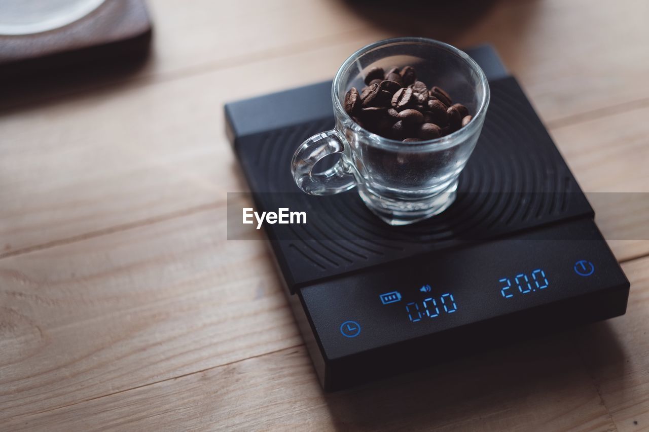 Coffee beans on digital scale in morning with vintage interior design