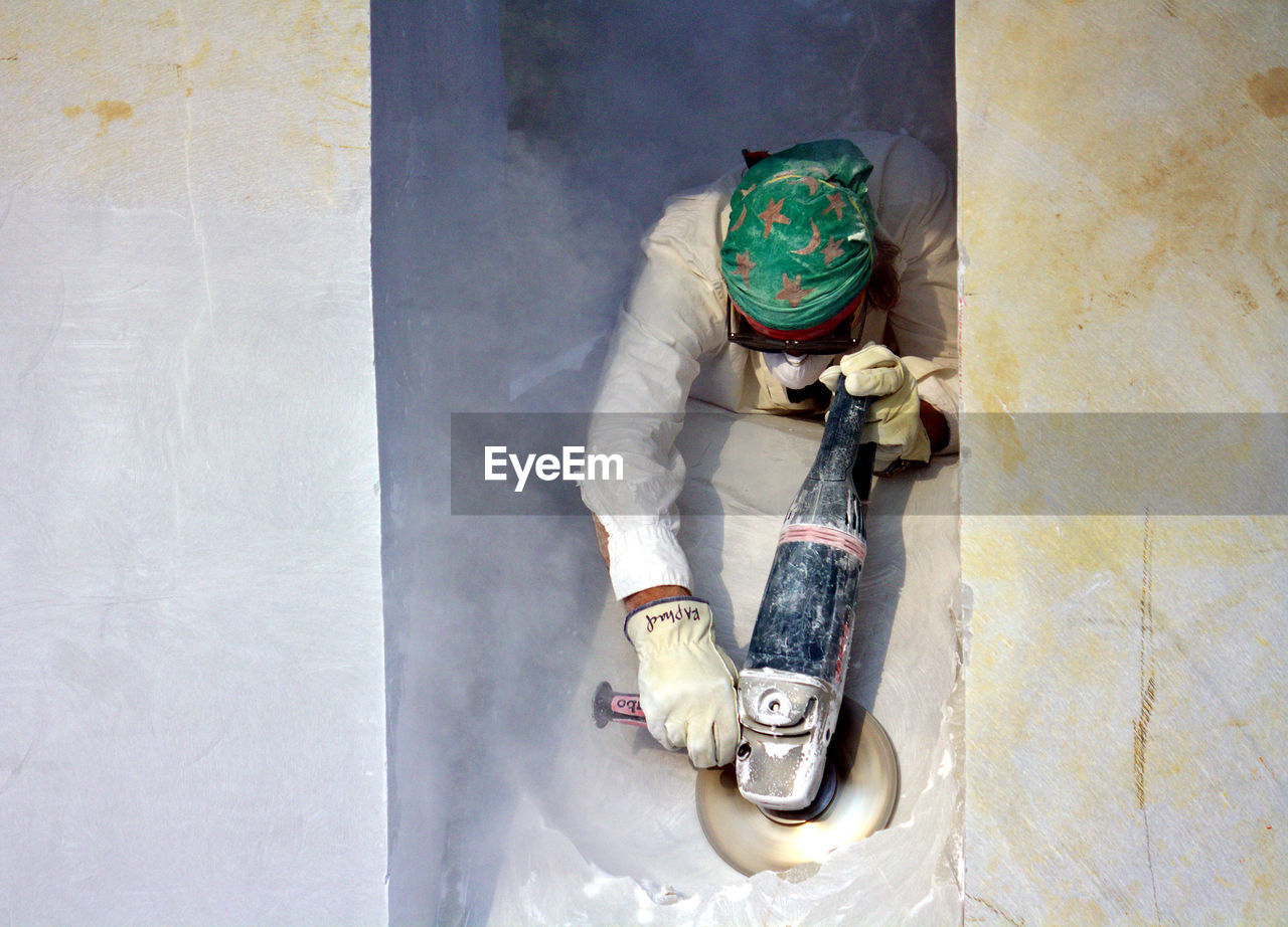 HIGH ANGLE VIEW OF MAN STANDING IN KITCHEN