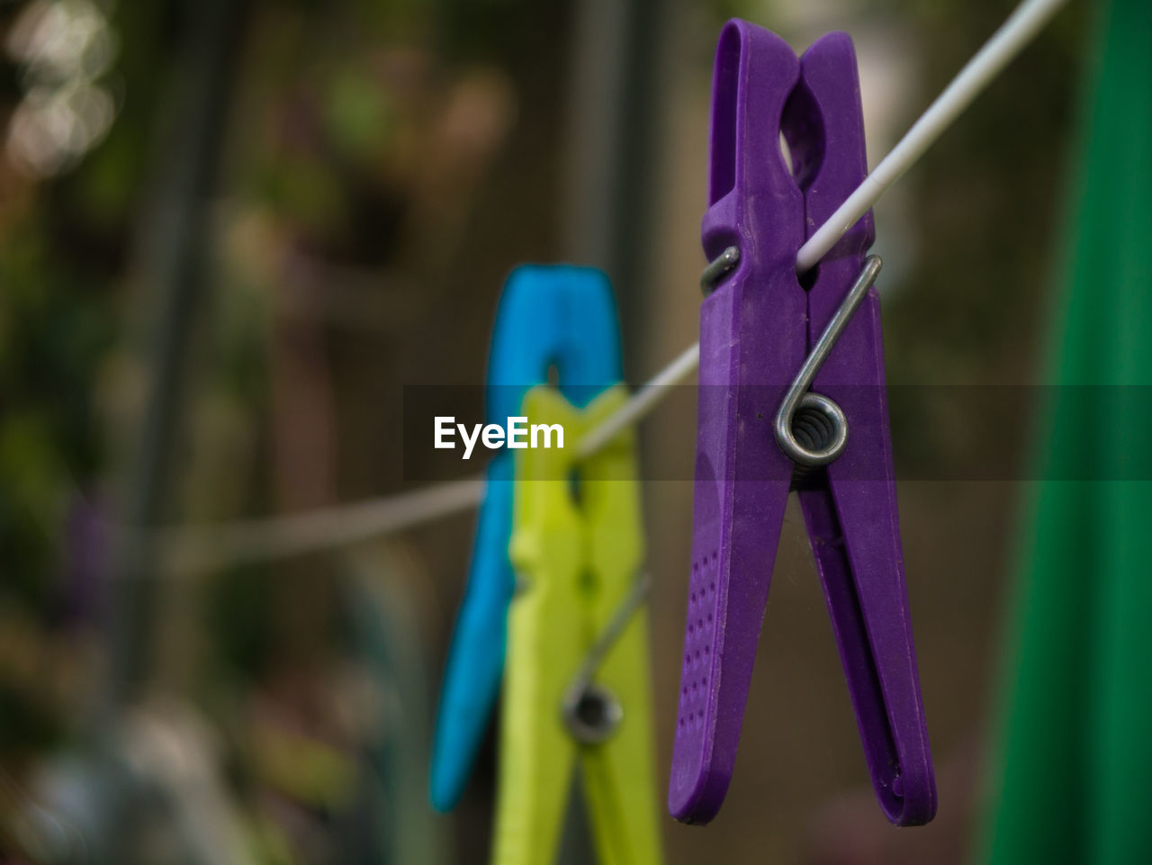 Close-up of clothespins on string in back yard