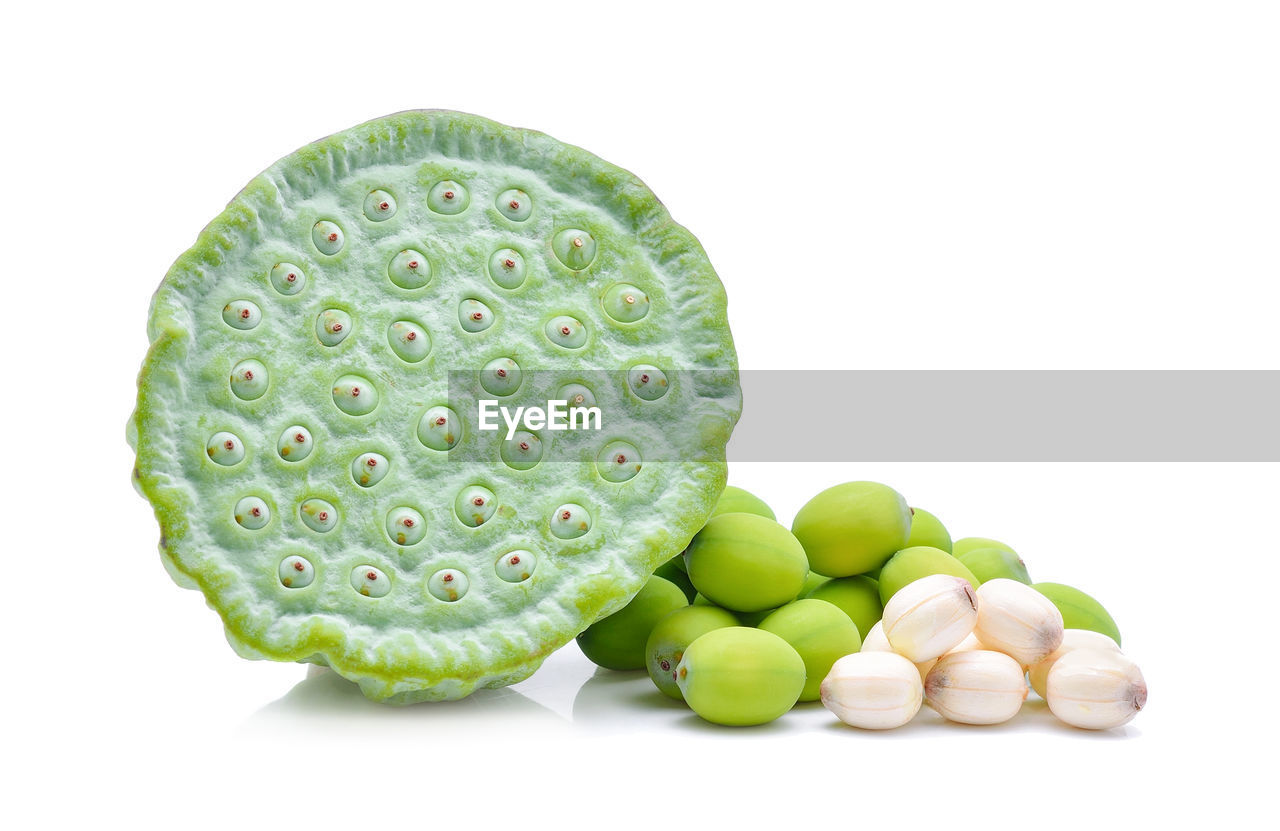 CLOSE-UP OF FRESH FRUITS AGAINST WHITE BACKGROUND OVER GRAY SURFACE