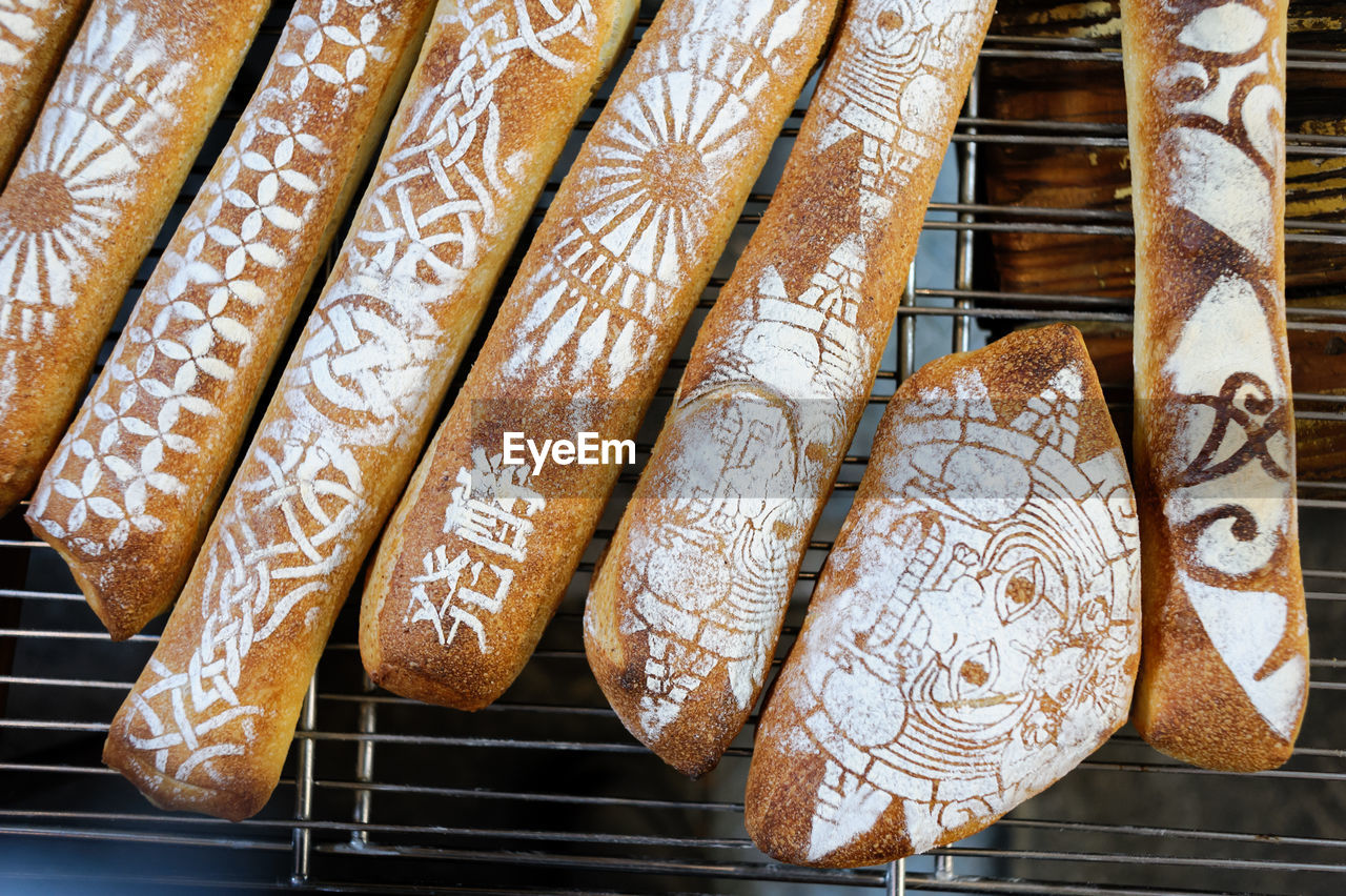 Directly above view of various baguette breads on metal grate at market