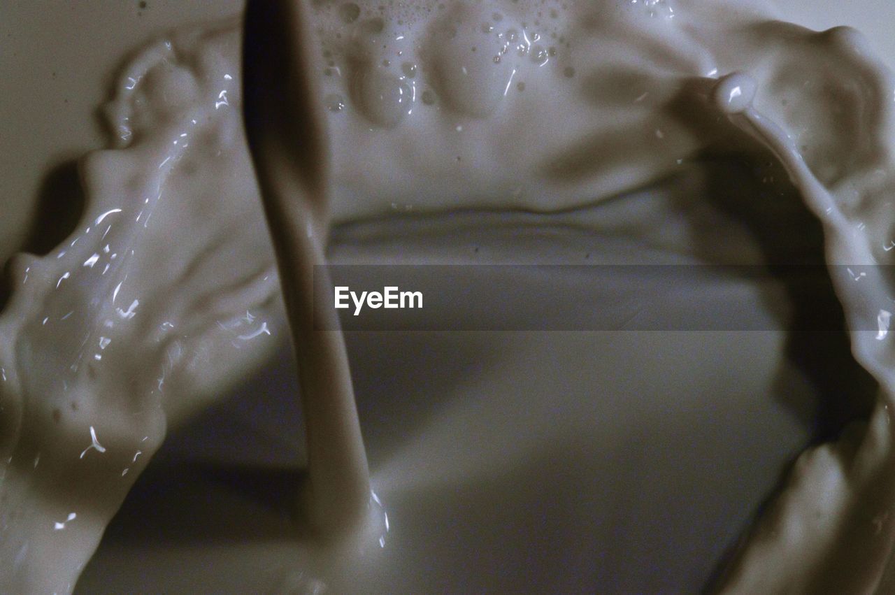 Close-up of milk pouring into container