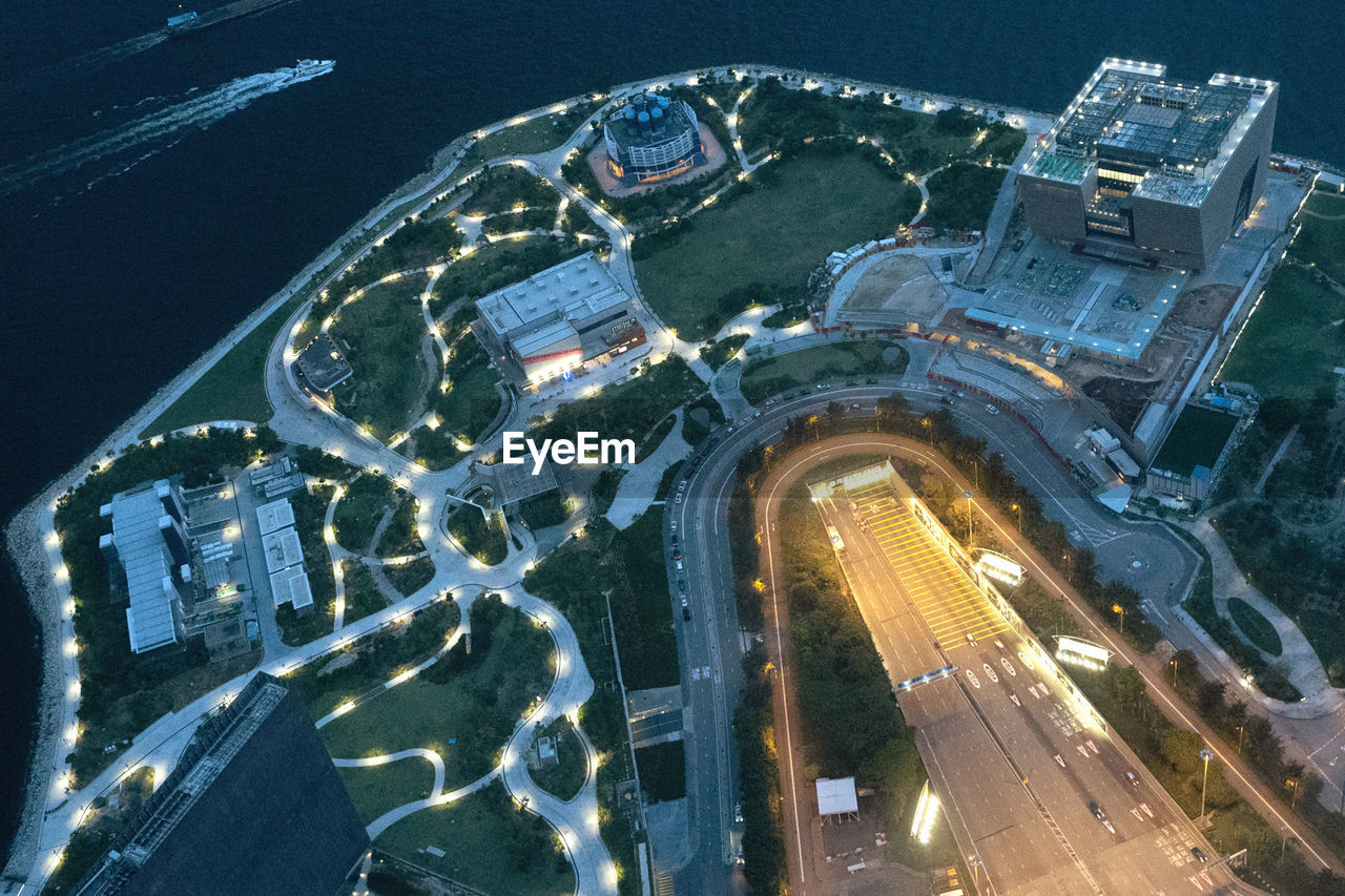 High angle view of illuminated city by buildings at night