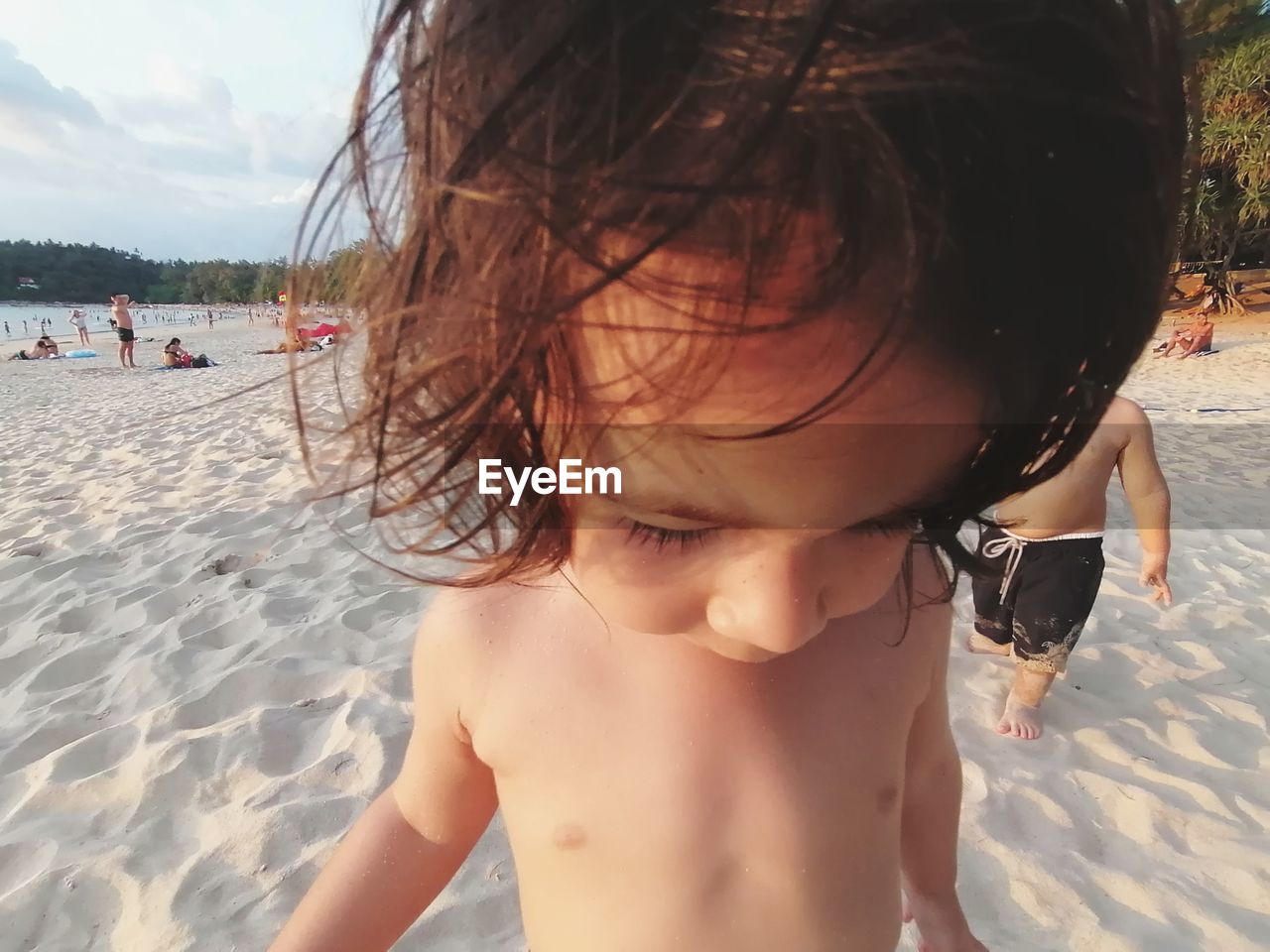 MIDSECTION OF SHIRTLESS BOY AT BEACH