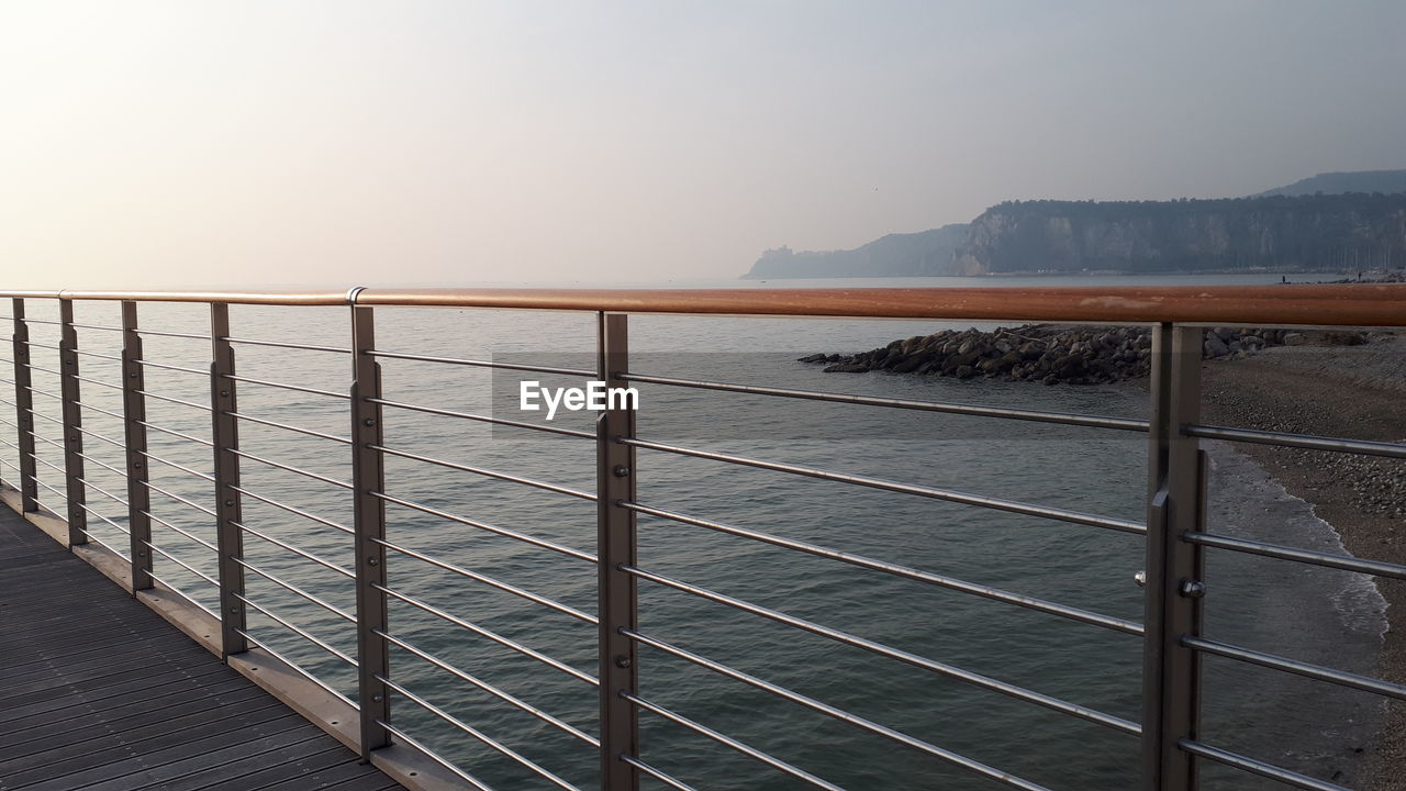 RAILING BY SEA AGAINST CLEAR SKY