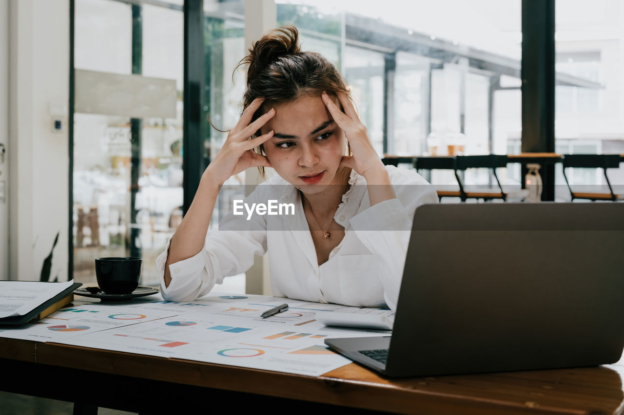 businesswoman using laptop at table in office
