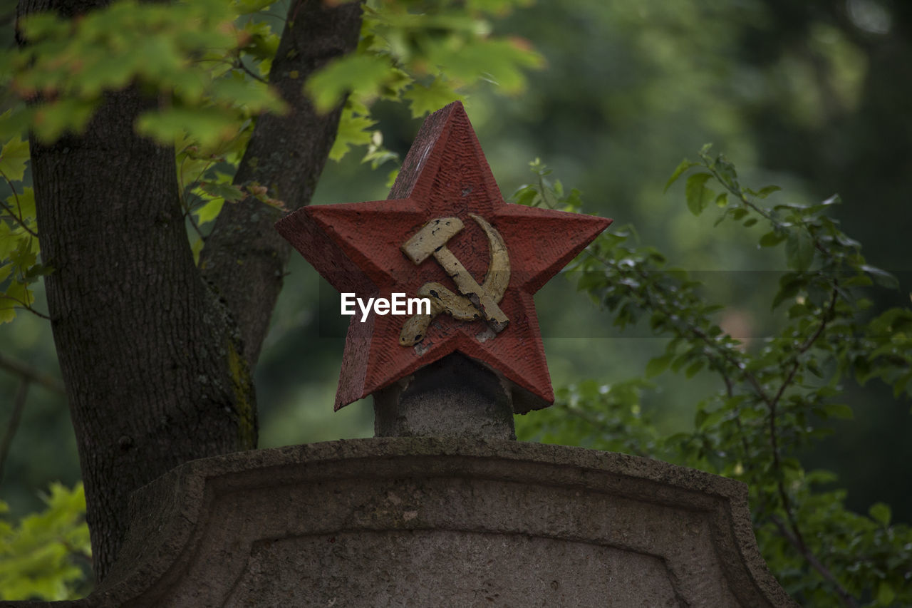 Lonesome red star with hammer and sickle on headstone at graveyard for fallen russian soldiers