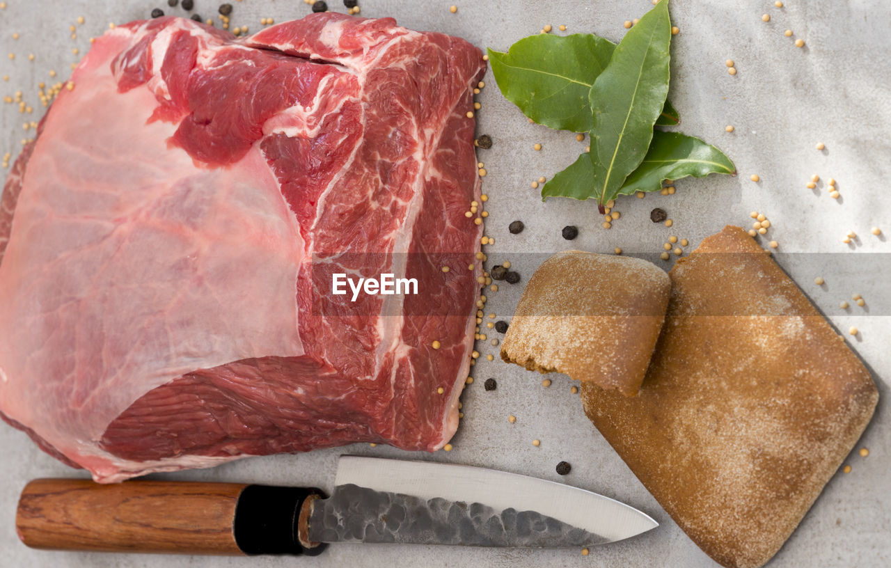 Directly above shot of beef with herbs and knife in plate