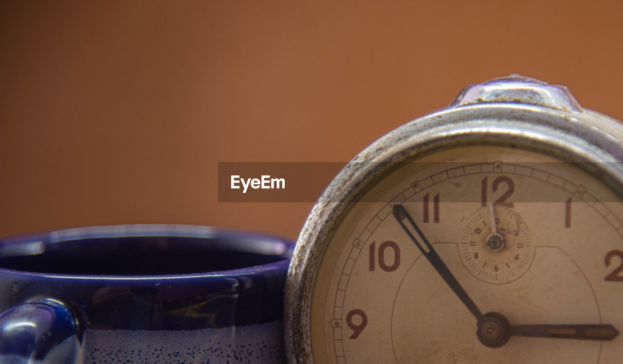 CLOSE-UP OF CLOCK AGAINST WALL