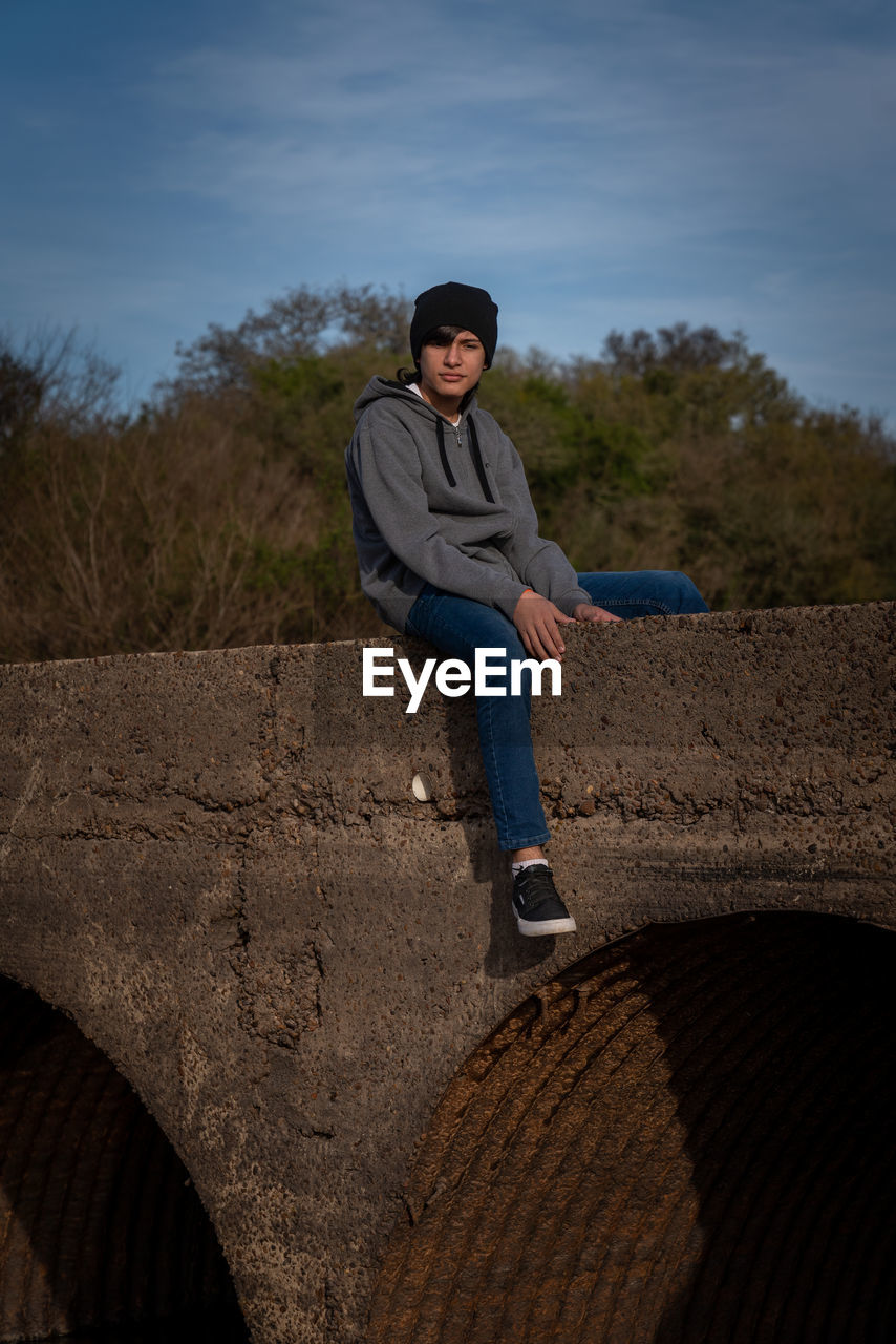 Young man posing on a broken bridge