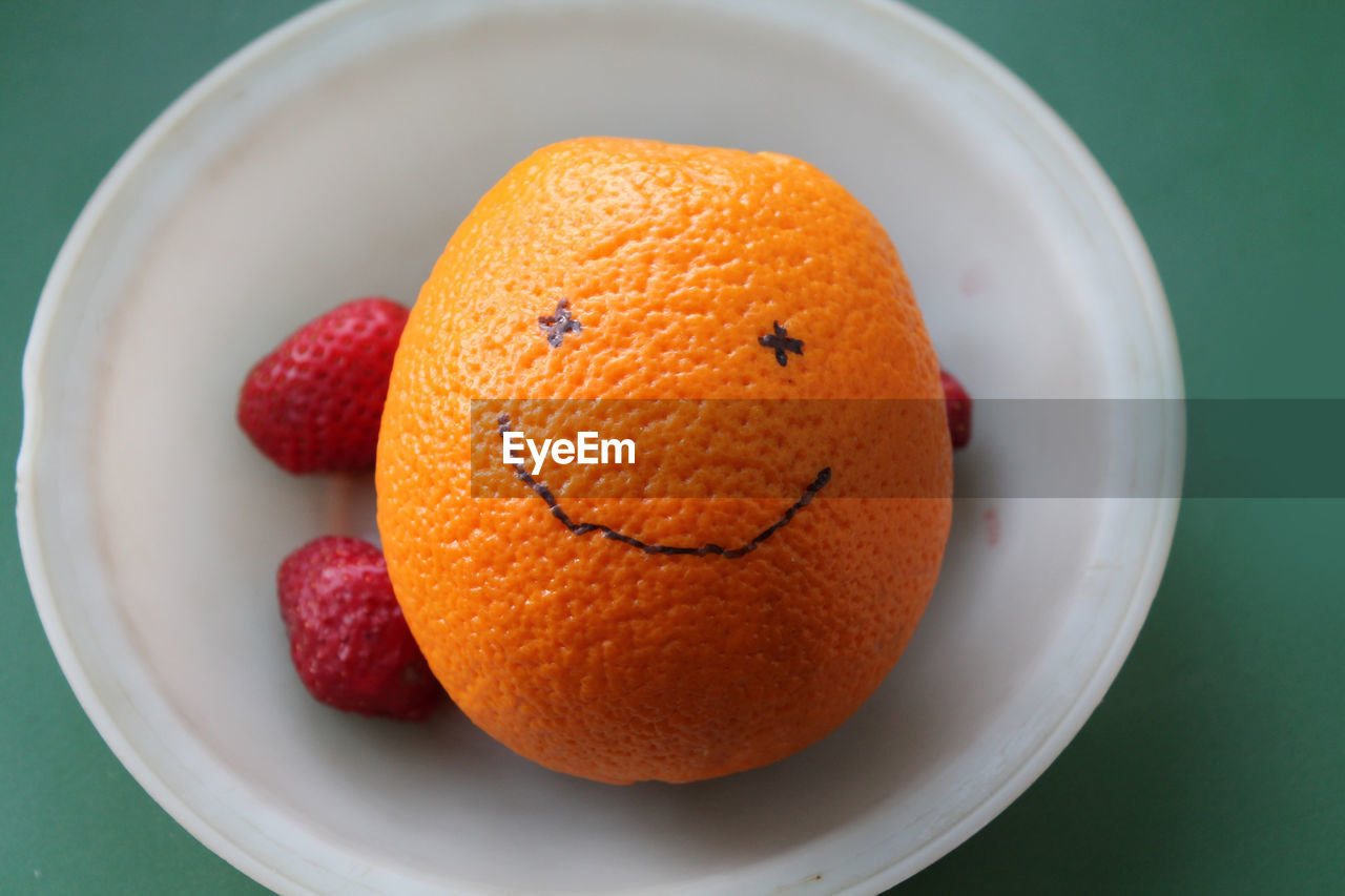 Smiling orange on a the green background