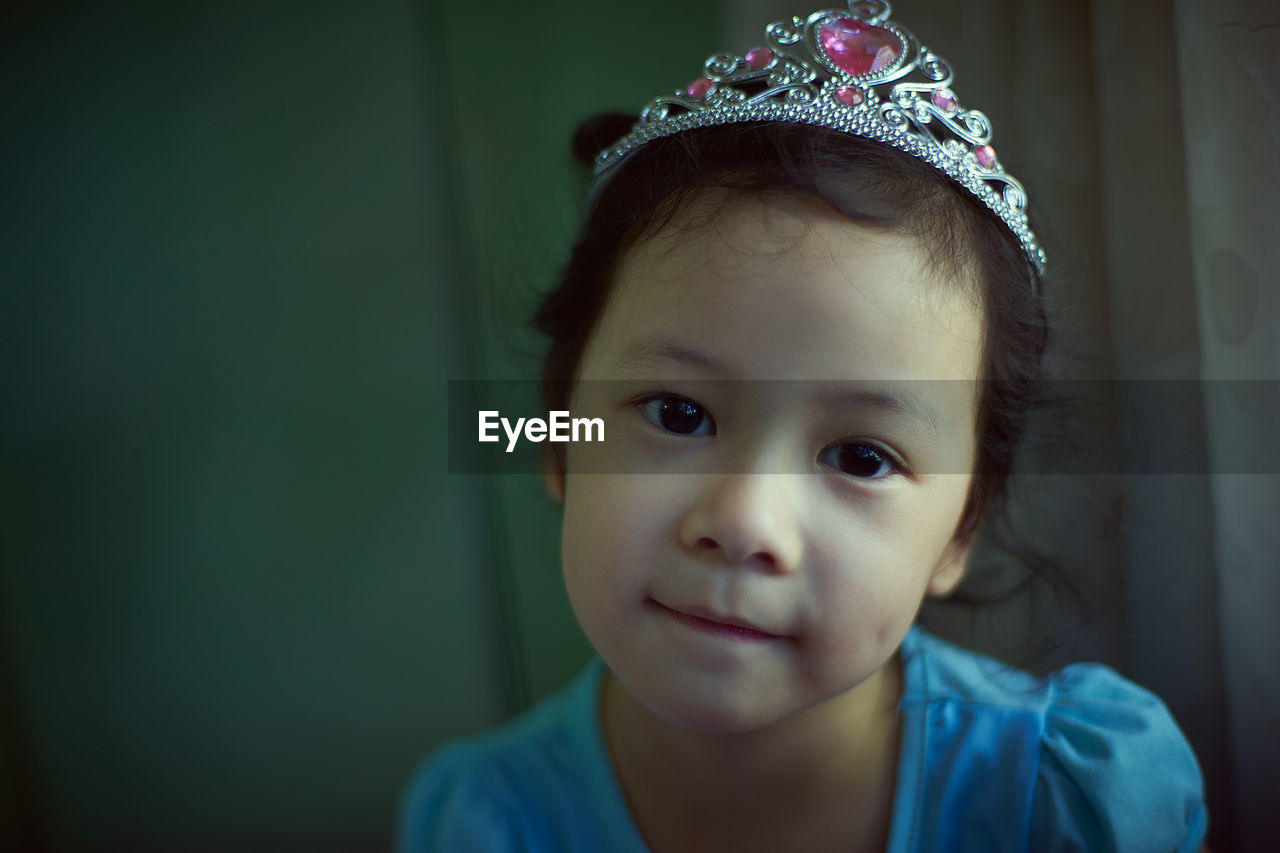 Portrait of girl wearing crown while sitting at home