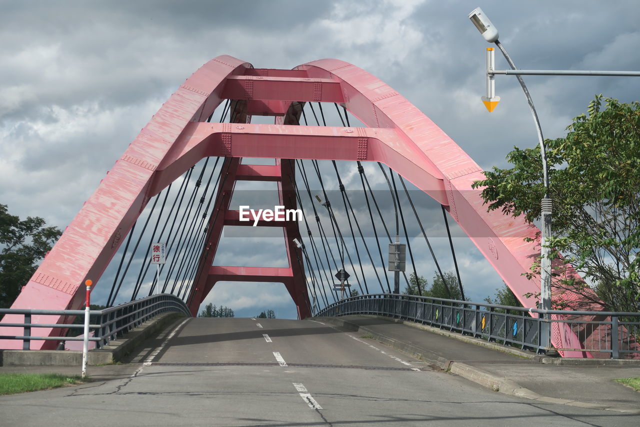 Bridge over road amidst buildings against sky