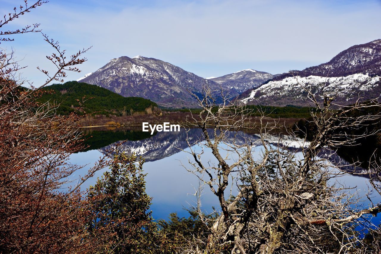 Idyllic view of calm lake and mountains against sky
