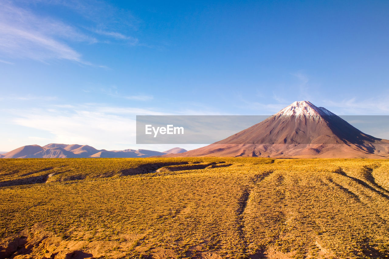 Scenic view of mountains against blue sky