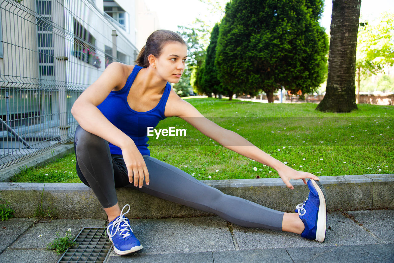 Full length of teenage girl exercising in park