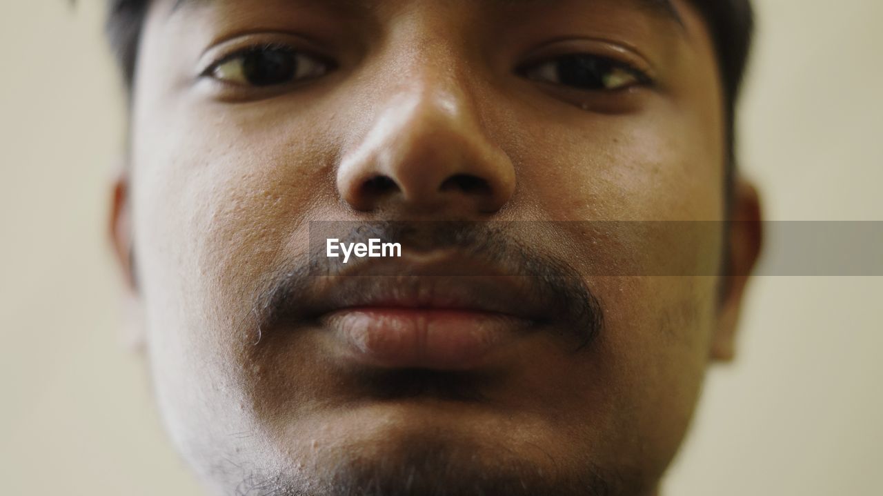Close-up portrait of young man against wall