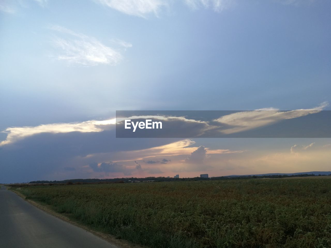 SCENIC VIEW OF ROAD AMIDST FIELD AGAINST SKY
