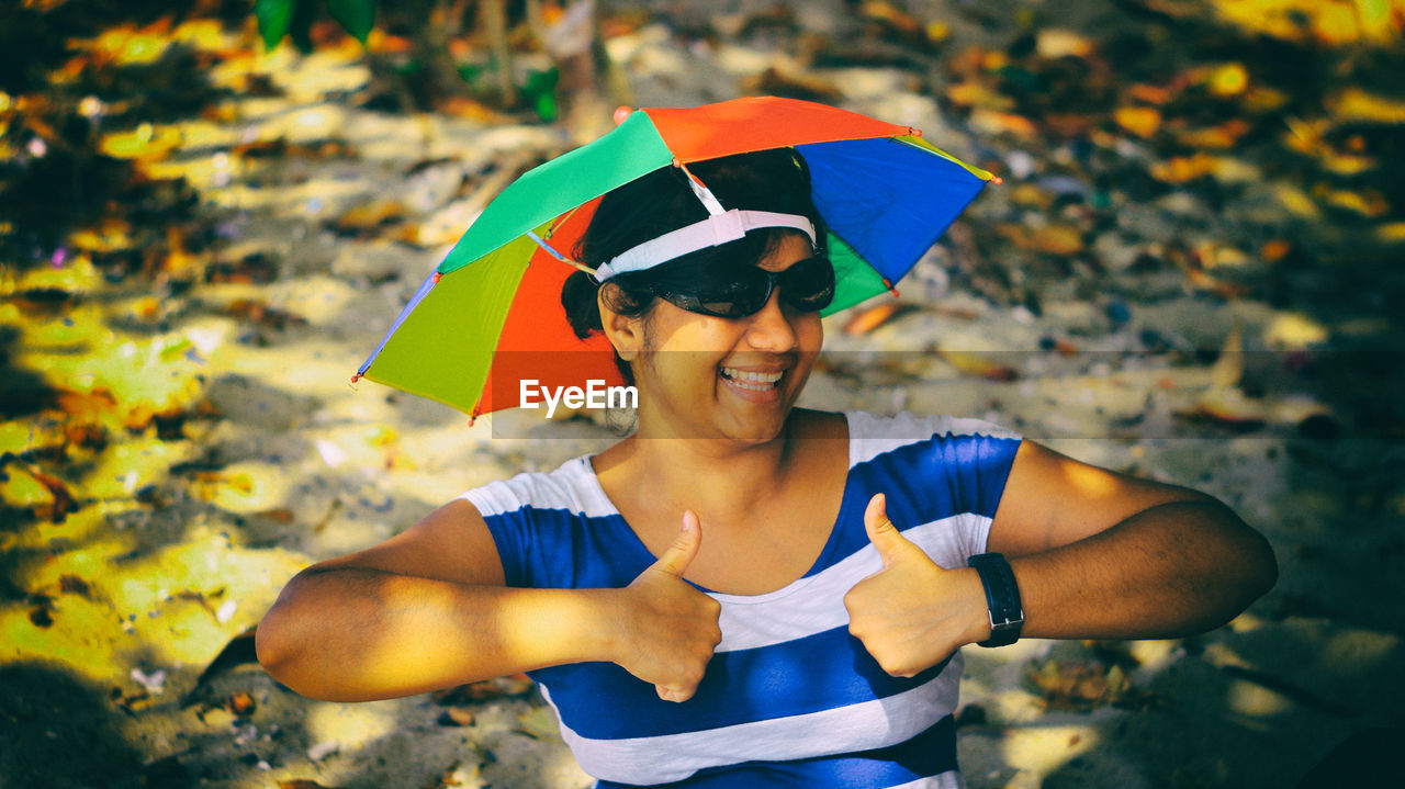 High angle view of woman gesturing while wearing head umbrella