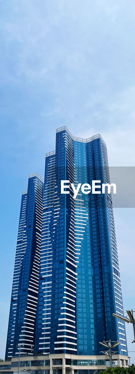 LOW ANGLE VIEW OF MODERN BUILDING AGAINST BLUE SKY