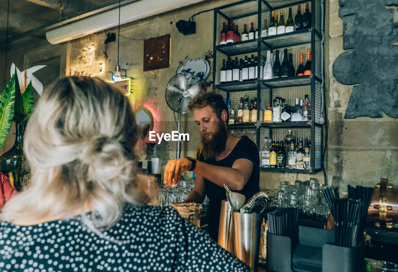 Girl and bartender in a cocktail bar.