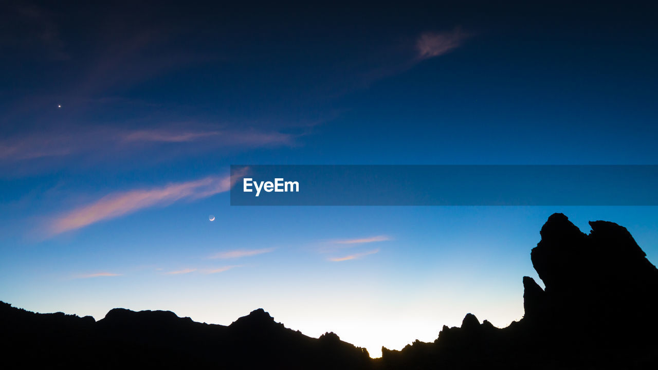 LOW ANGLE VIEW OF SILHOUETTE MOUNTAINS AGAINST SKY