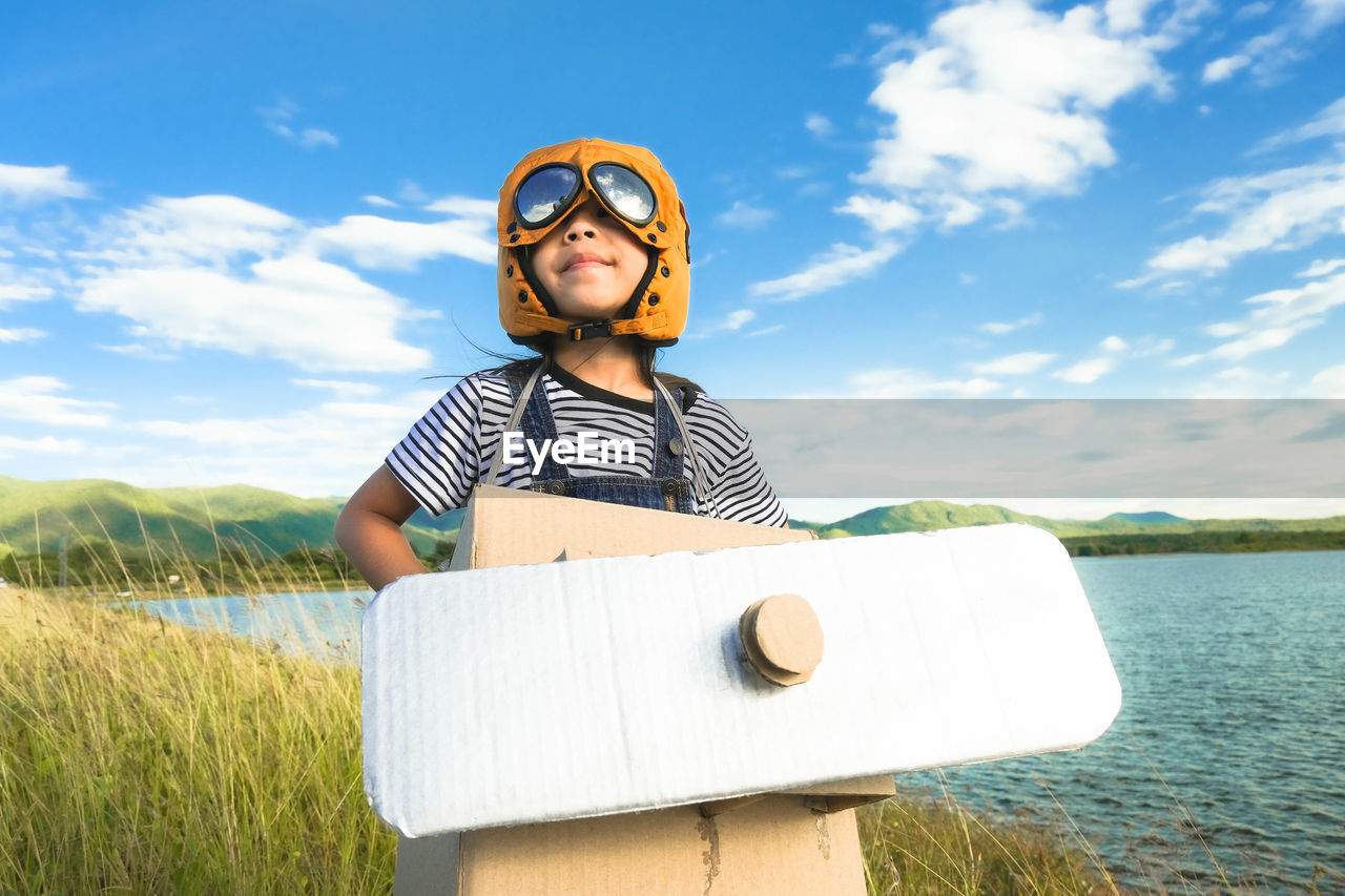 Low angle view of young man wearing sunglasses against sky