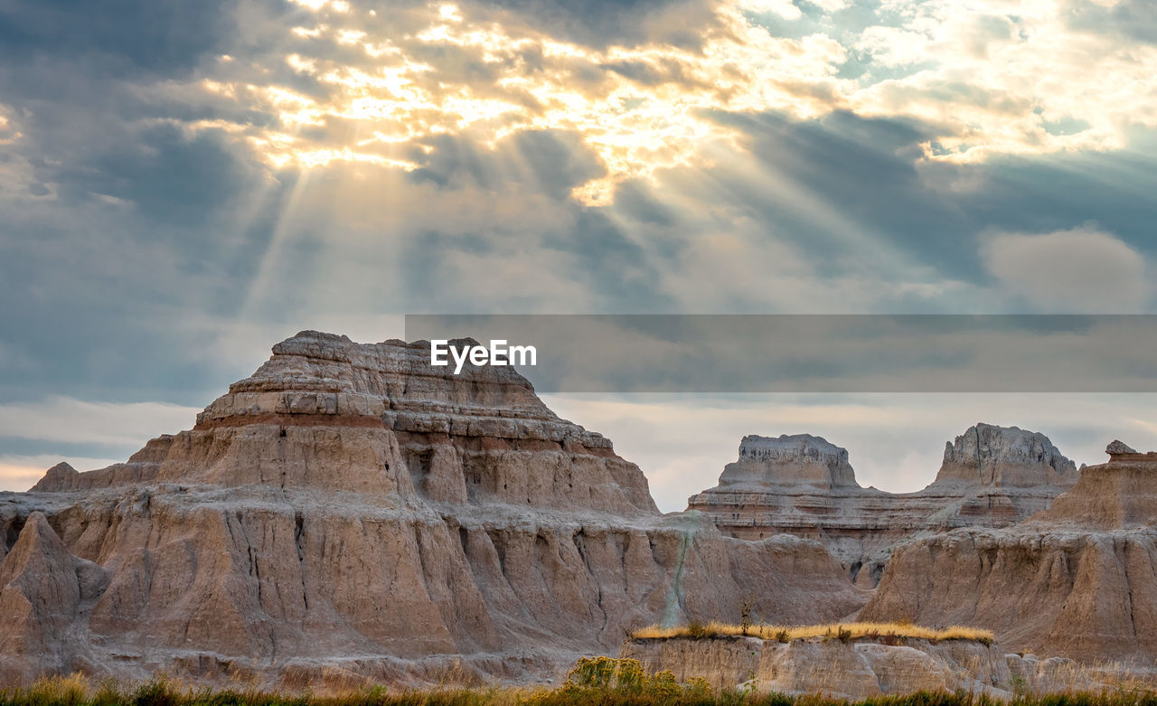 Rock formations against cloudy sky