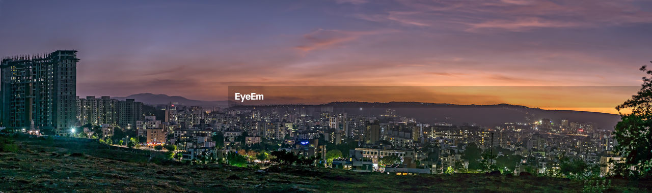 Panorama image of beautiful evening sky in the city with some lights in buildings. 