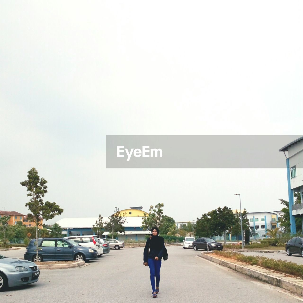 REAR VIEW OF MAN ON CAR AGAINST SKY