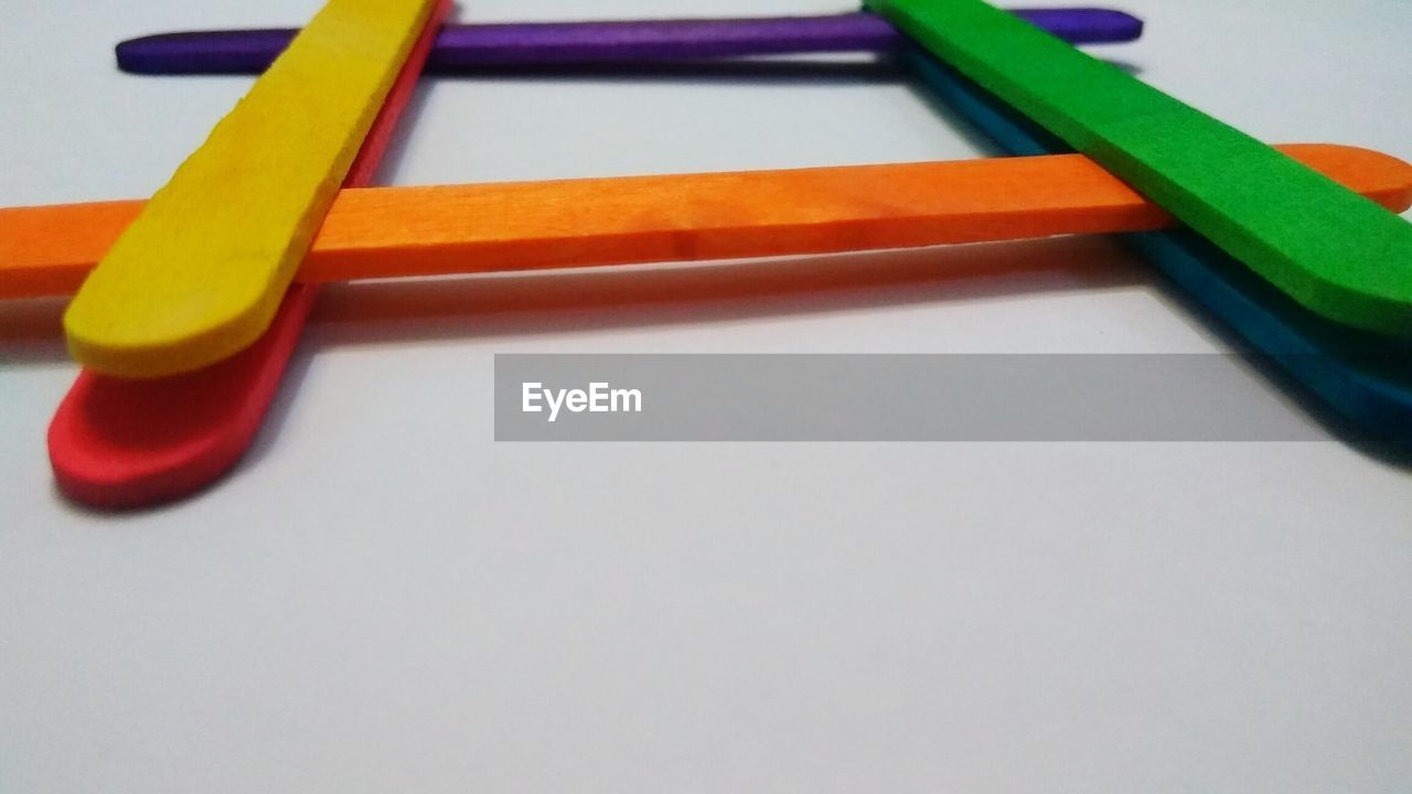 CLOSE-UP OF MULTI COLORED PENCILS ON WHITE BACKGROUND