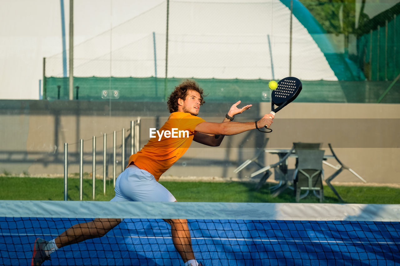 portrait of young man playing tennis in court