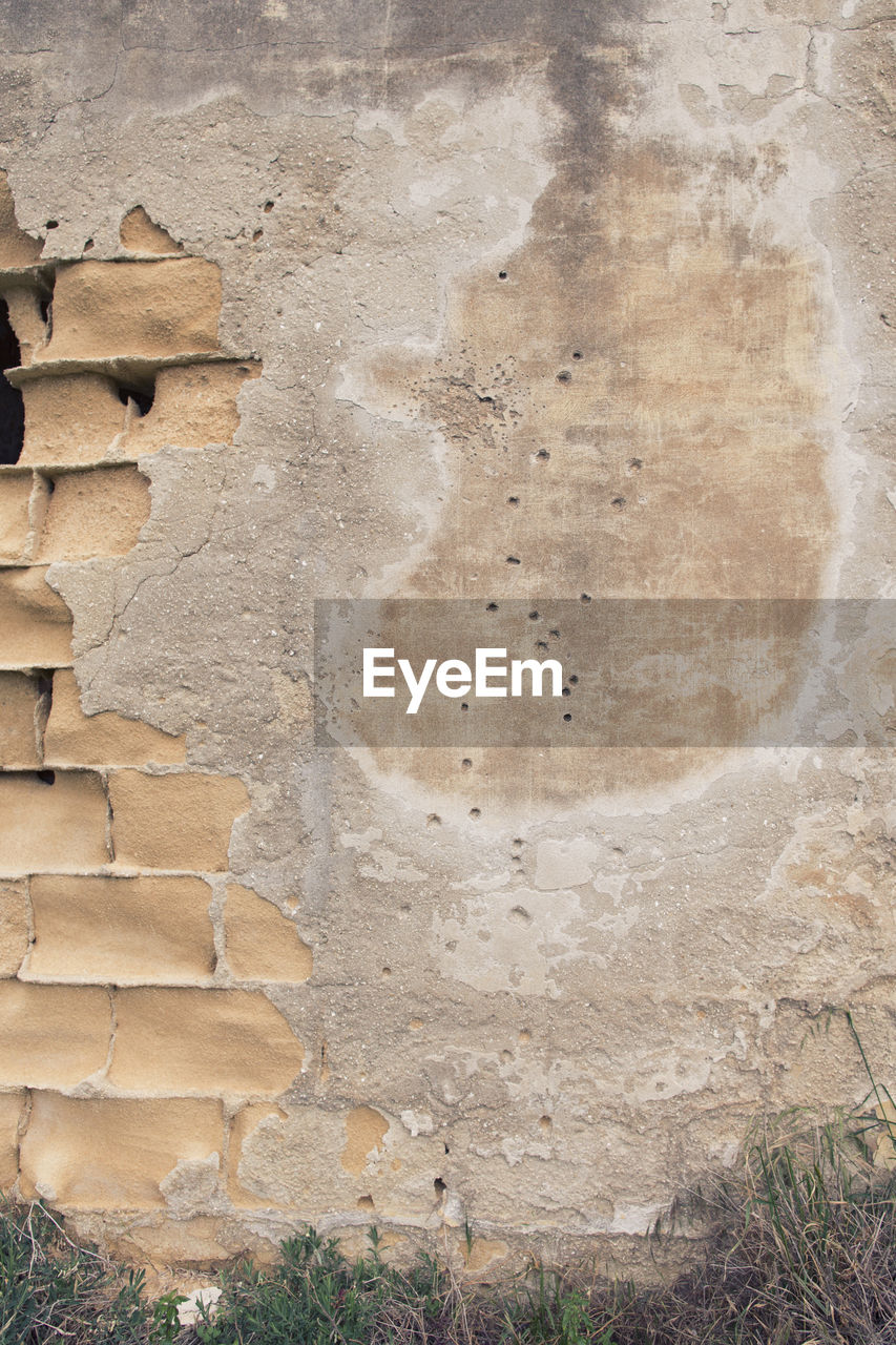 VIEW OF BRICK WALL WITH WEATHERED WALLS