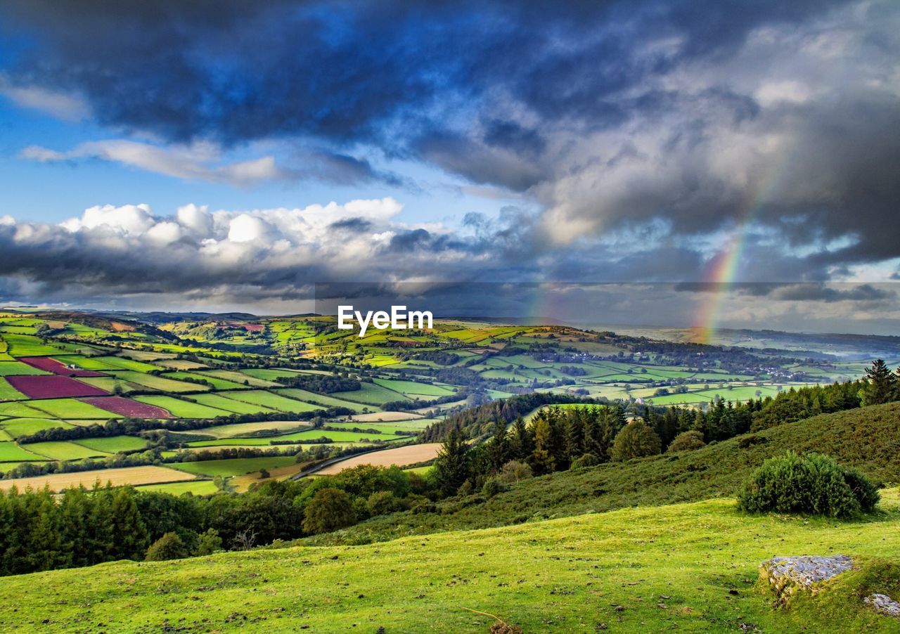 Scenic view of agricultural field against dramatic sky