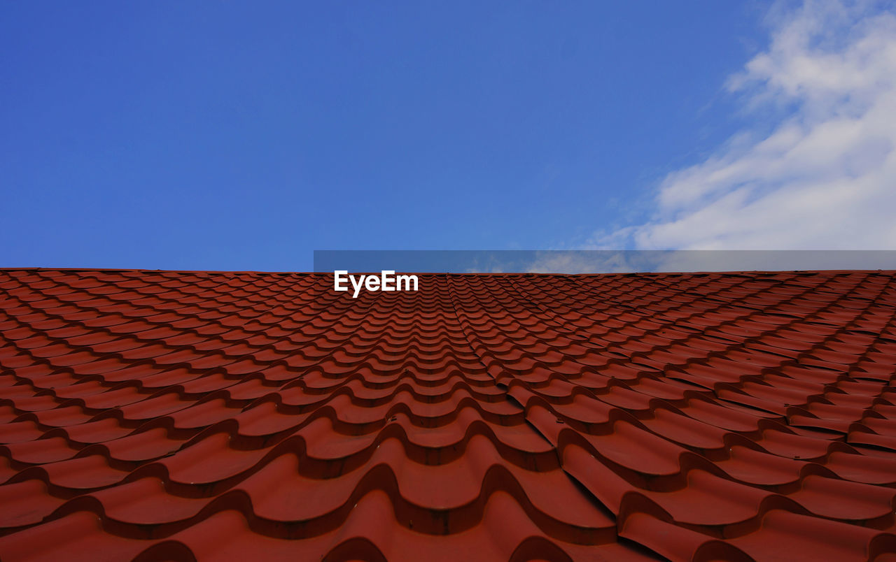 Low angle view of building roof against blue sky