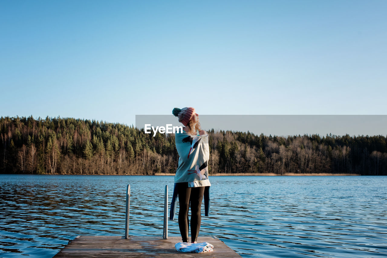 Woman standing drying in the sun after cold water ice swimming