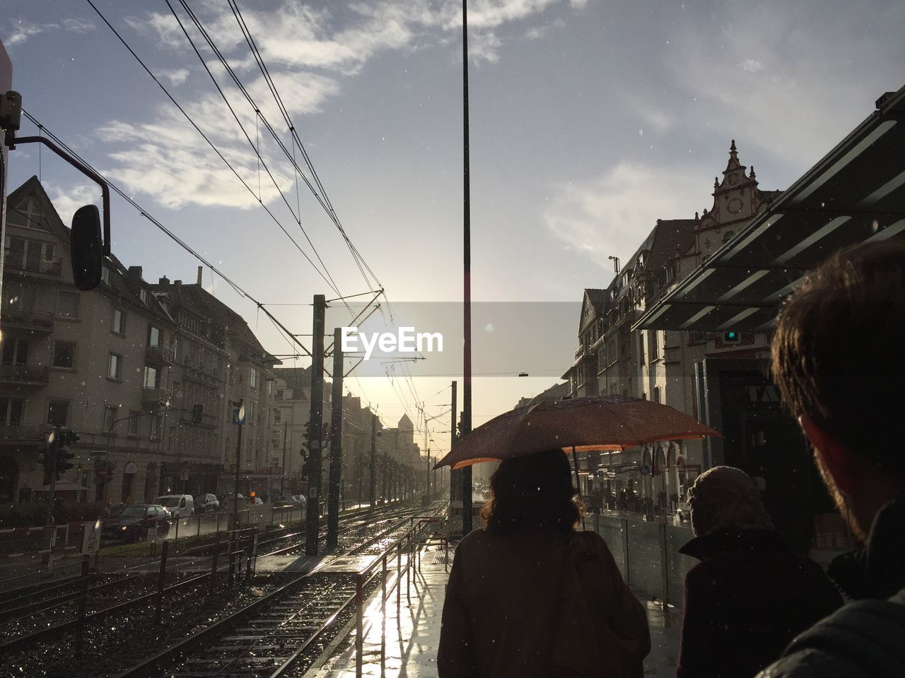 People at railroad station against sky