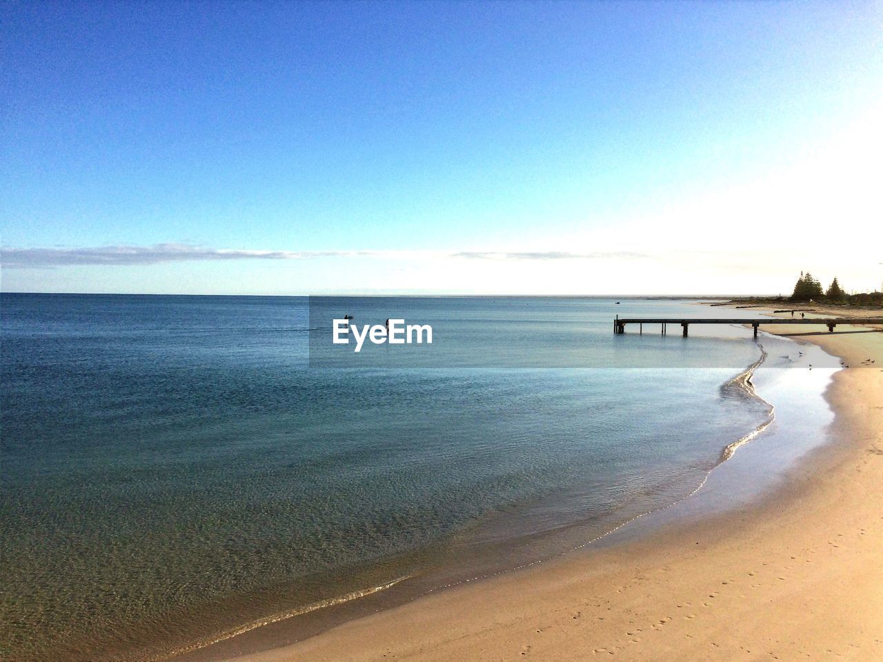 Scenic view of beach against clear blue sky