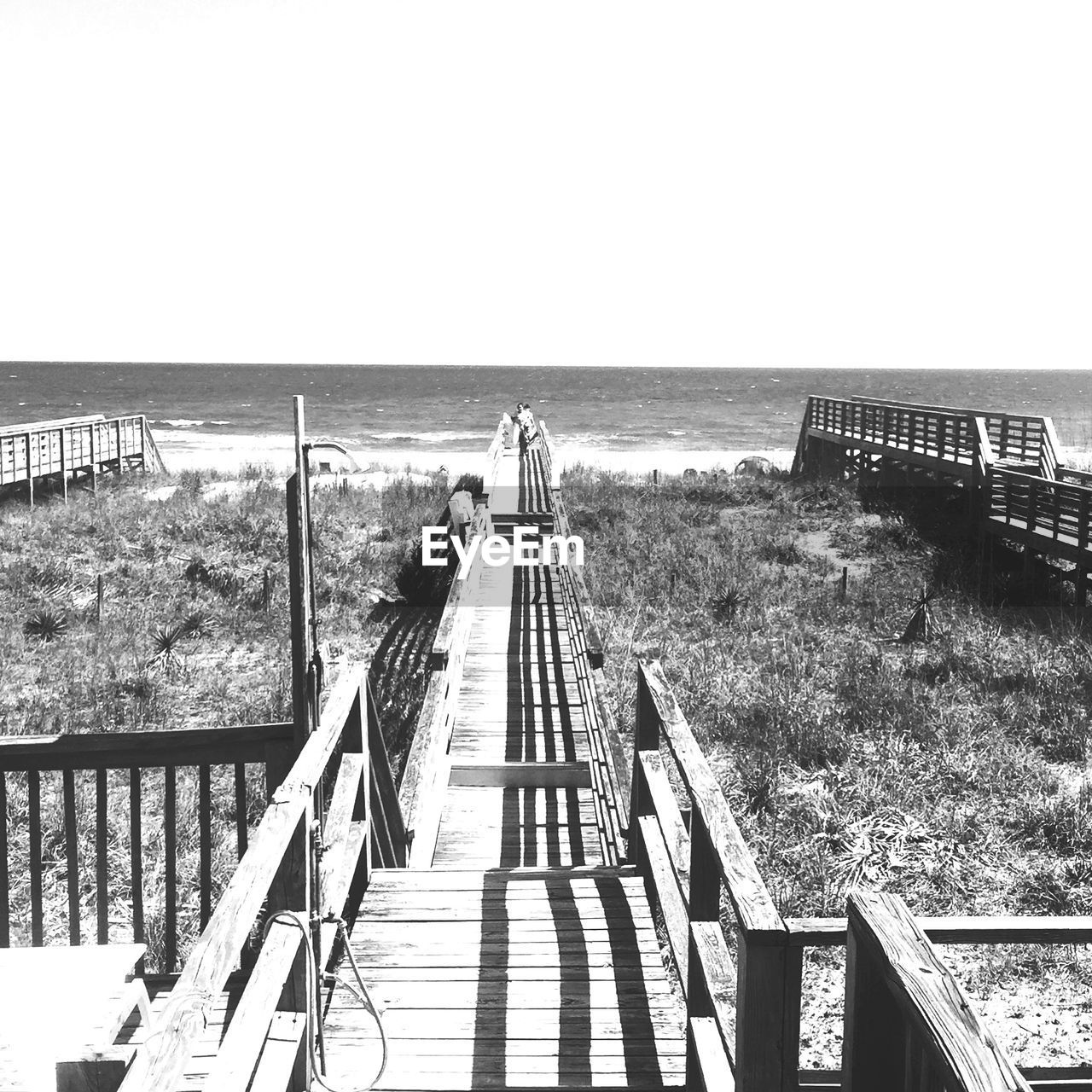 Boardwalk at beach against clear sky