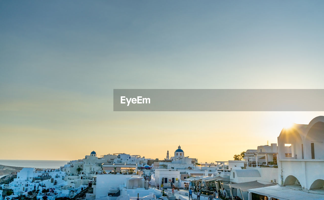 Panoramic view of oia town in santorini island with old whitewashed houses and traditional windmill, 