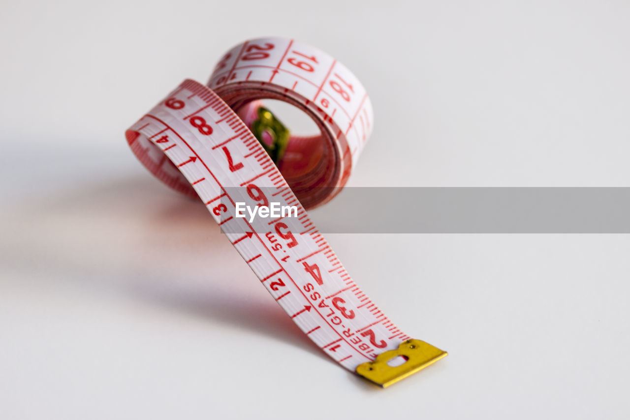 Close-up of tape measure over white background