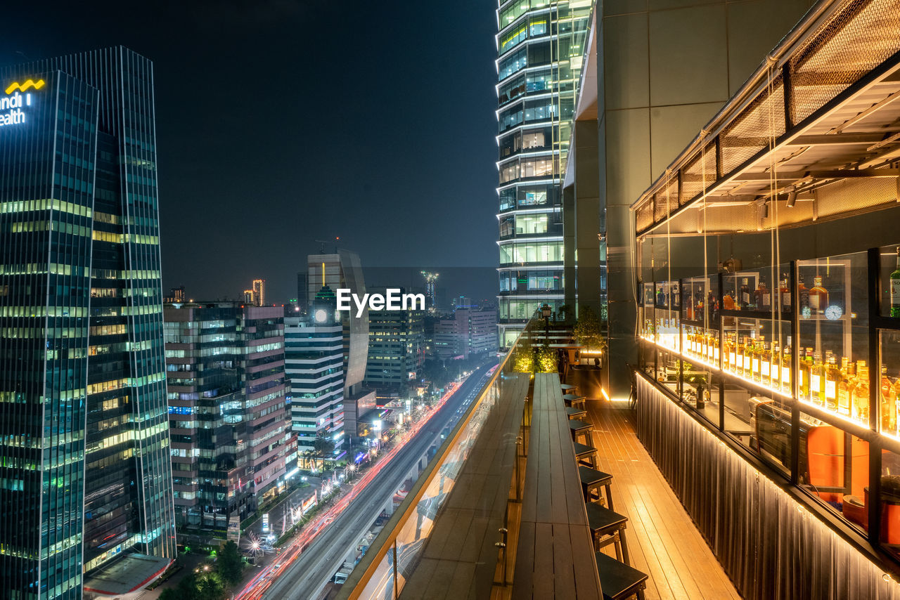 PANORAMIC VIEW OF ILLUMINATED BUILDINGS AT NIGHT