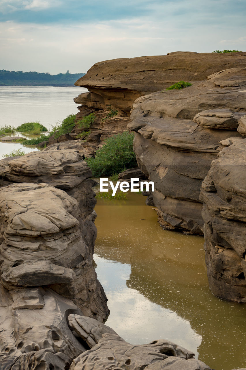 SCENIC VIEW OF ROCK FORMATIONS ON SEA AGAINST SKY