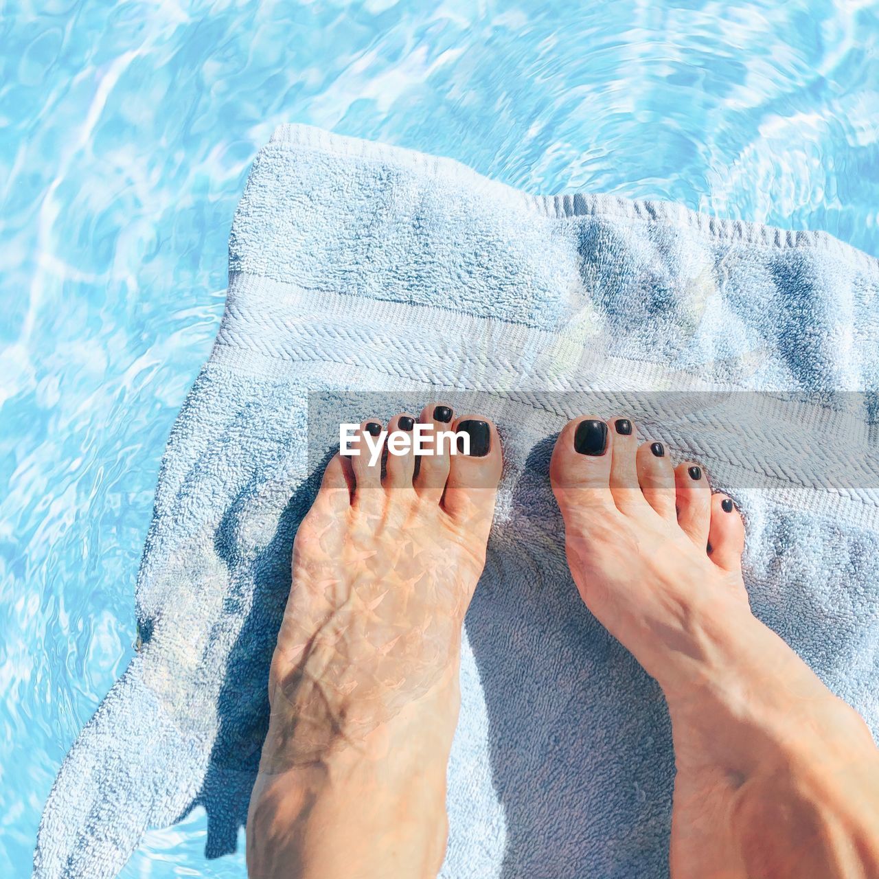 Low section of woman with towel in swimming pool