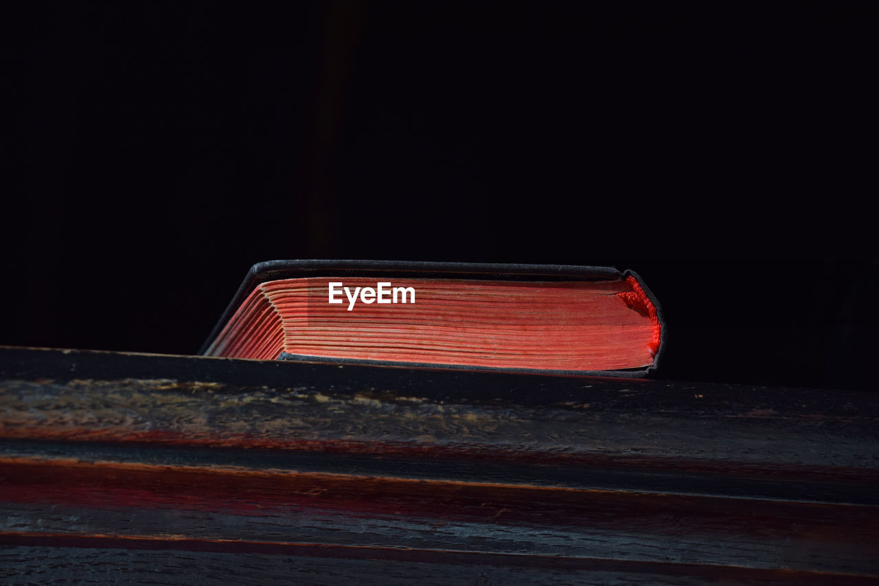 Low angle close-up of book on wooden shelf