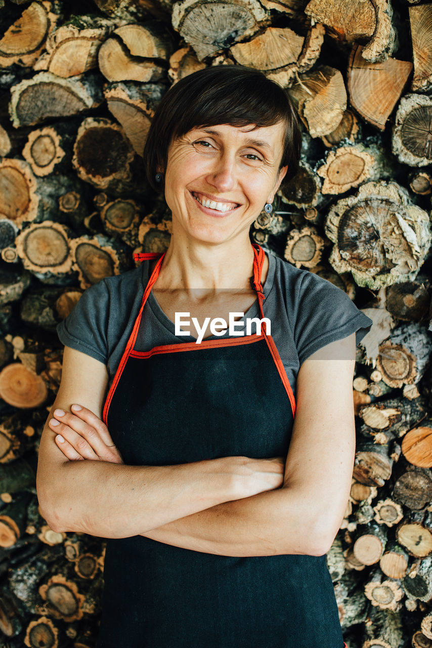 Portrait of female woodworker looking at camera and smiling, close up