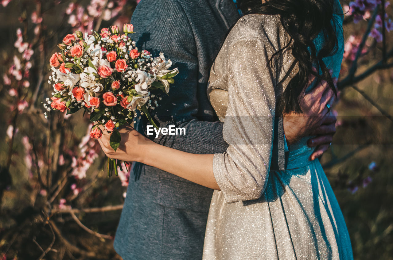 Midsection of woman holding flower bouquet